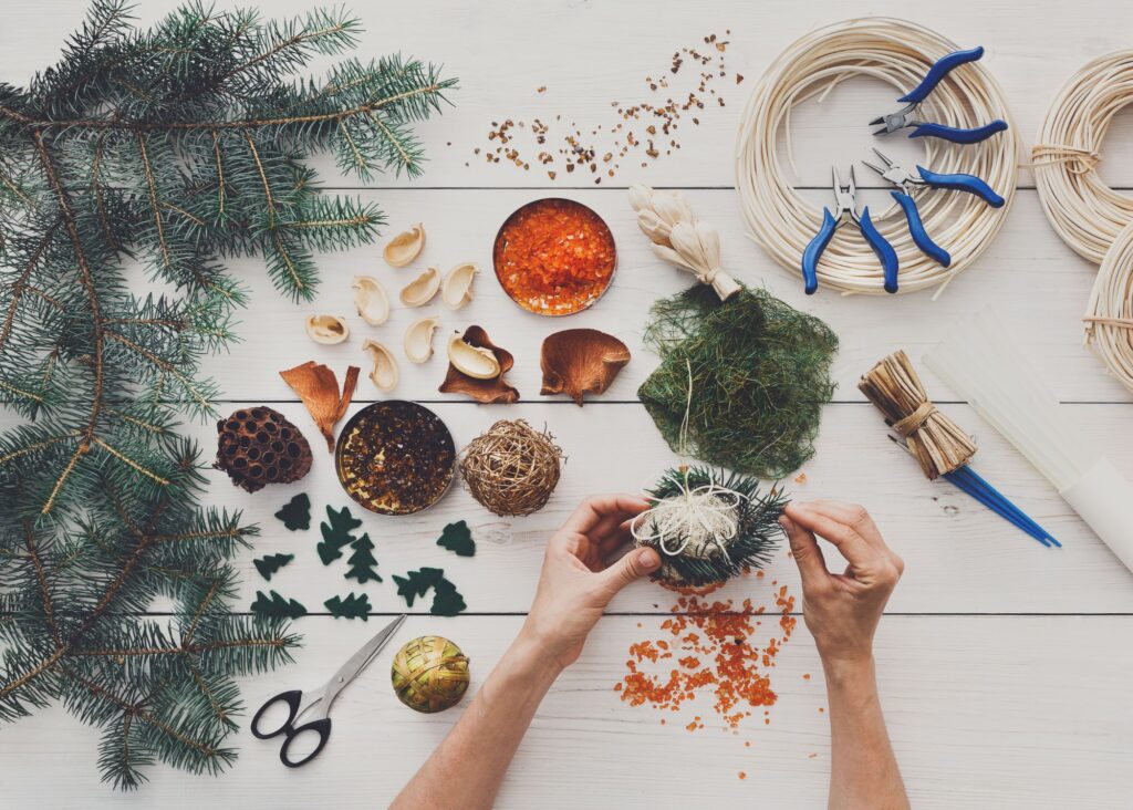 Hands crafting a simple, natural Christmas wreath, demonstrating Provision Over Pressure and Physical Stewardship during the Grammar Stage.