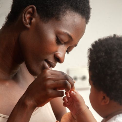 Mother gently feeding her young child during a quiet winter moment, reflecting the Great Pause for families with small children.
