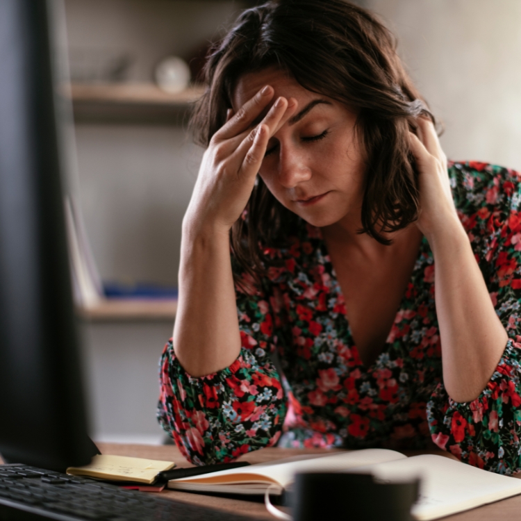 Weary homeschool mother feeling overwhelmed while planning lessons at a desk